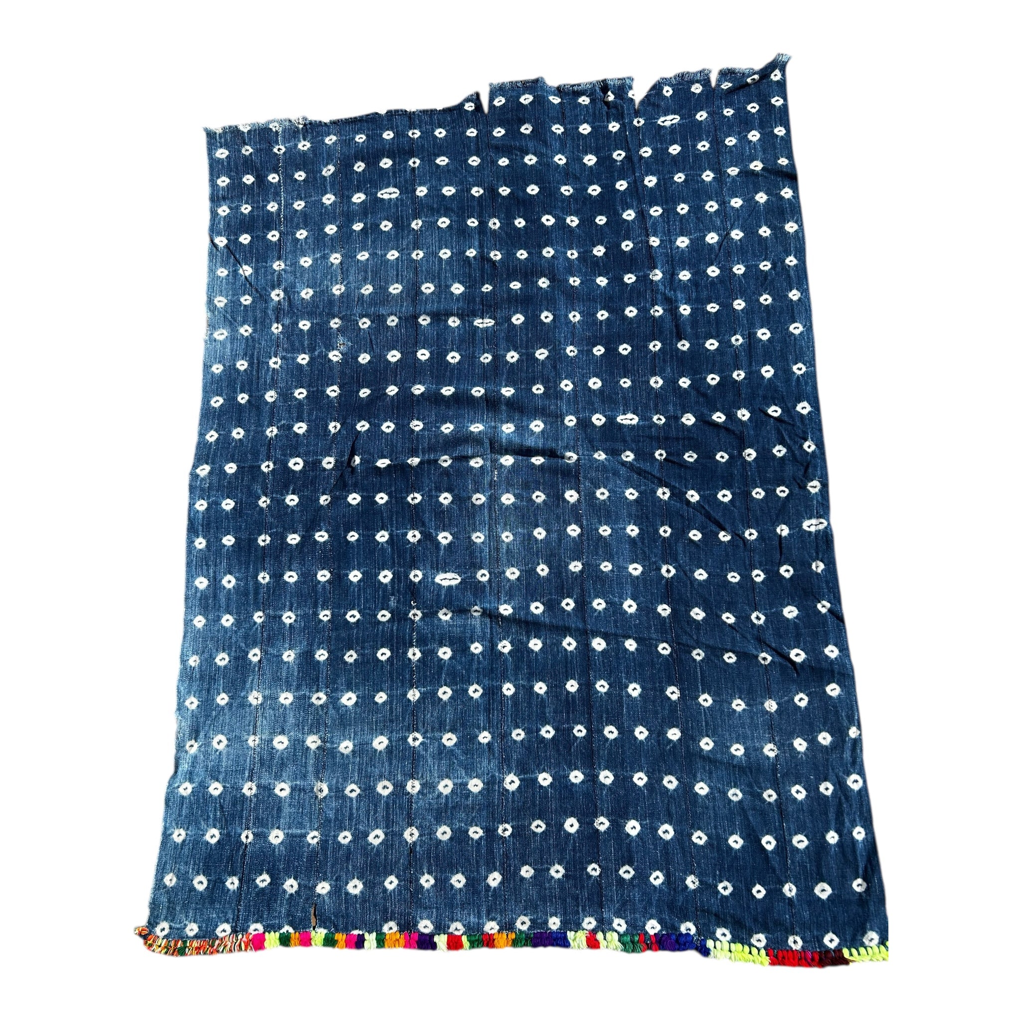 Blue fabric with white patterns and colorful trim on a white background