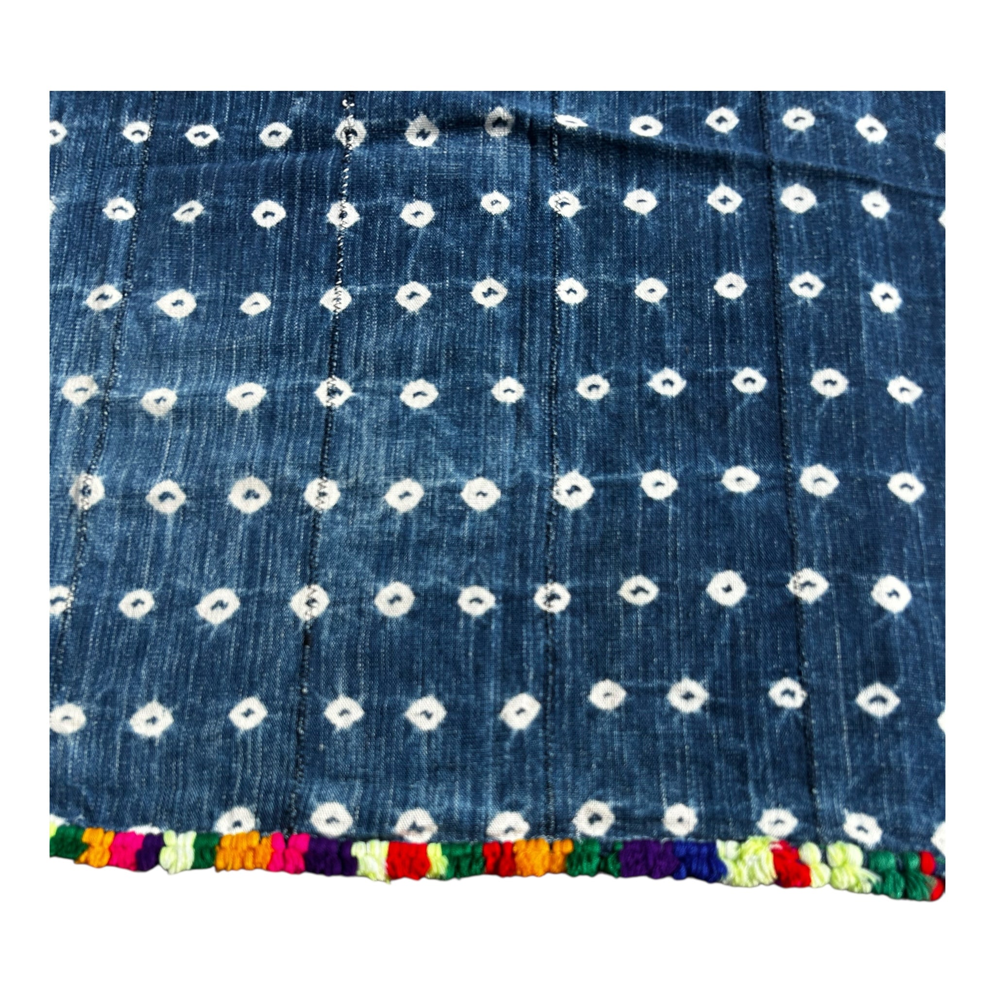 Blue fabric with white floral patterns and colorful trim on a white background